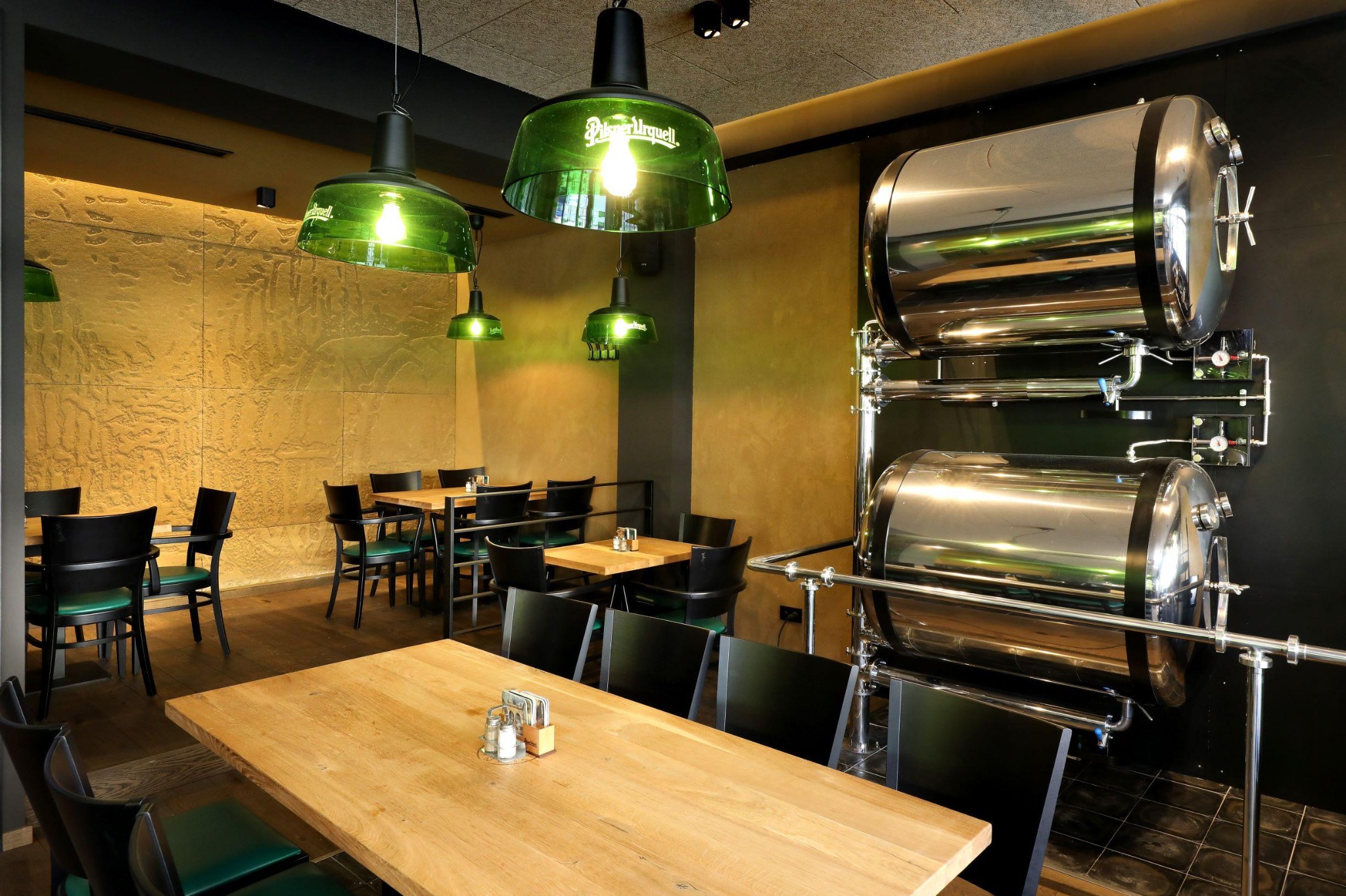 Prostorný interiér restaurace se zelenými lampami